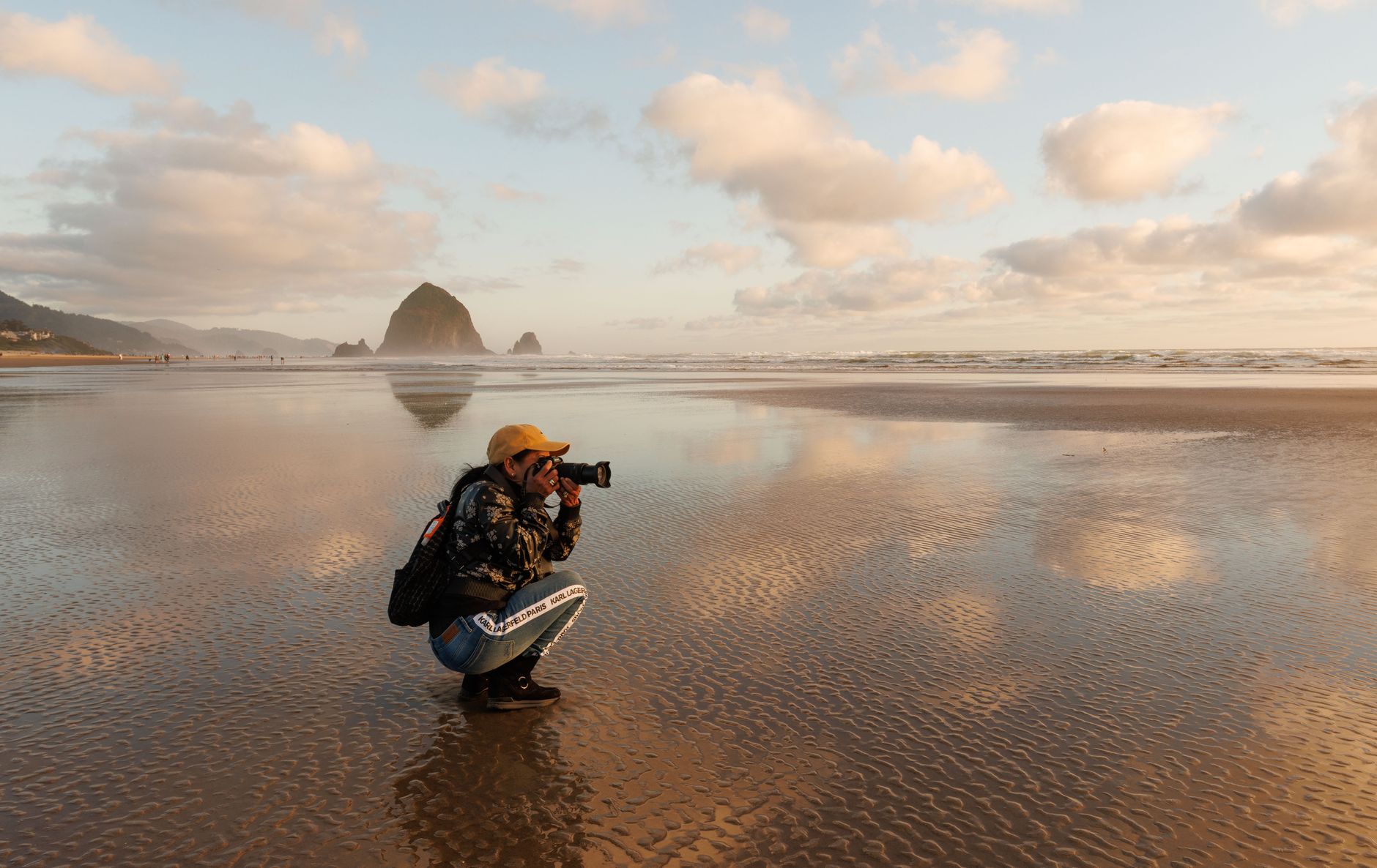 photographer capturing haystack rock at sunset